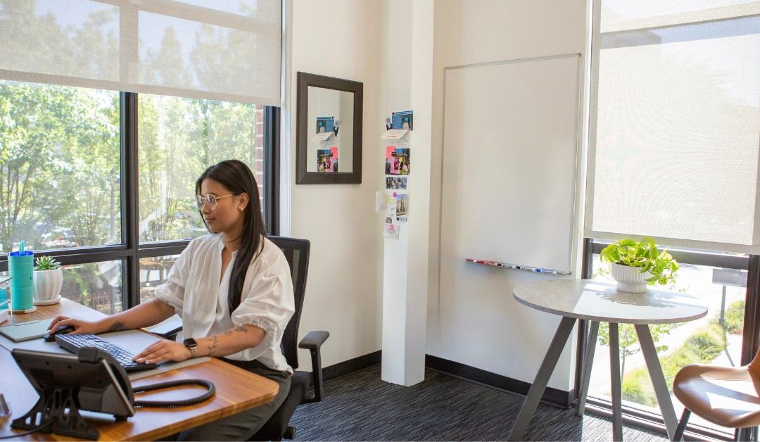 Woman in corner office at The District Coworking & Flex Office.